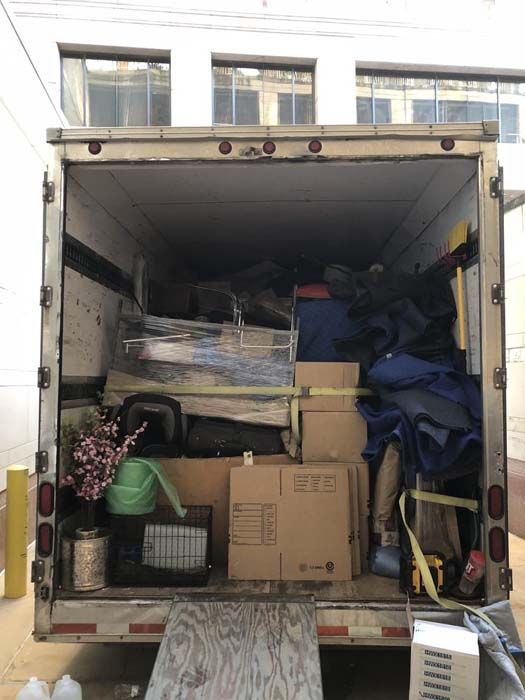 Open moving truck filled with boxes, furniture, and personal belongings.