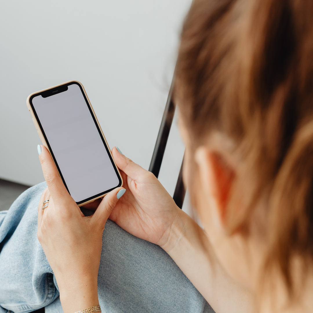 Person holding a smartphone and looking at a blank screen indoors