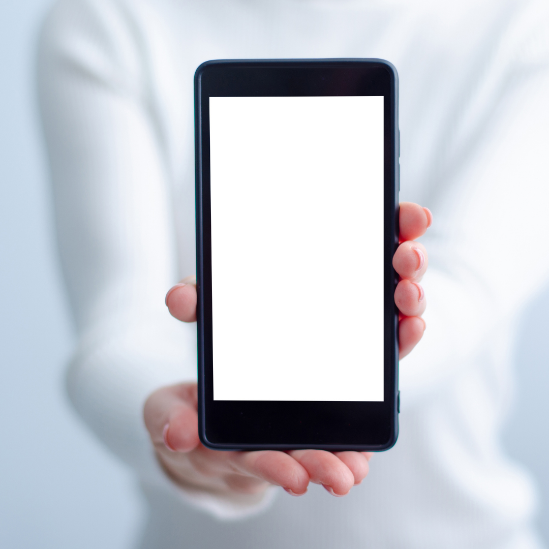 Person holding a smartphone with a blank white screen against a light background