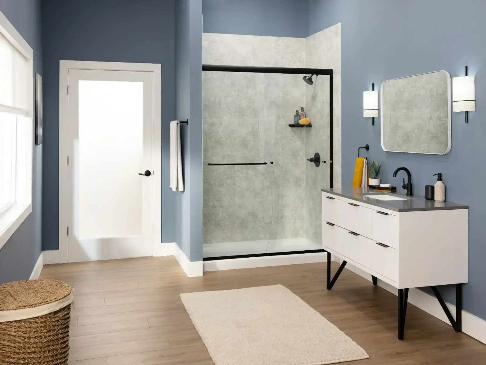 Modern gray bathroom with wall mirror, dark vanity, and white bathtub with black shelf