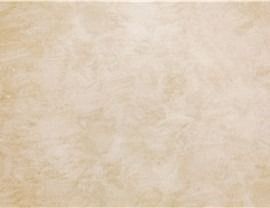 A textured, light beige surface with subtle, mottled marbling effects.