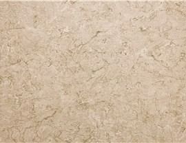 A close-up of beige marble stone with subtle, light brown veining and a natural, textured pattern.
