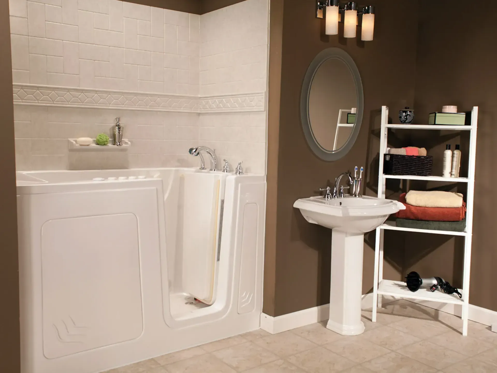 A walk-in bathtub next to a white pedestal sink and a white wooden shelf in a bathroom with dark brown walls.