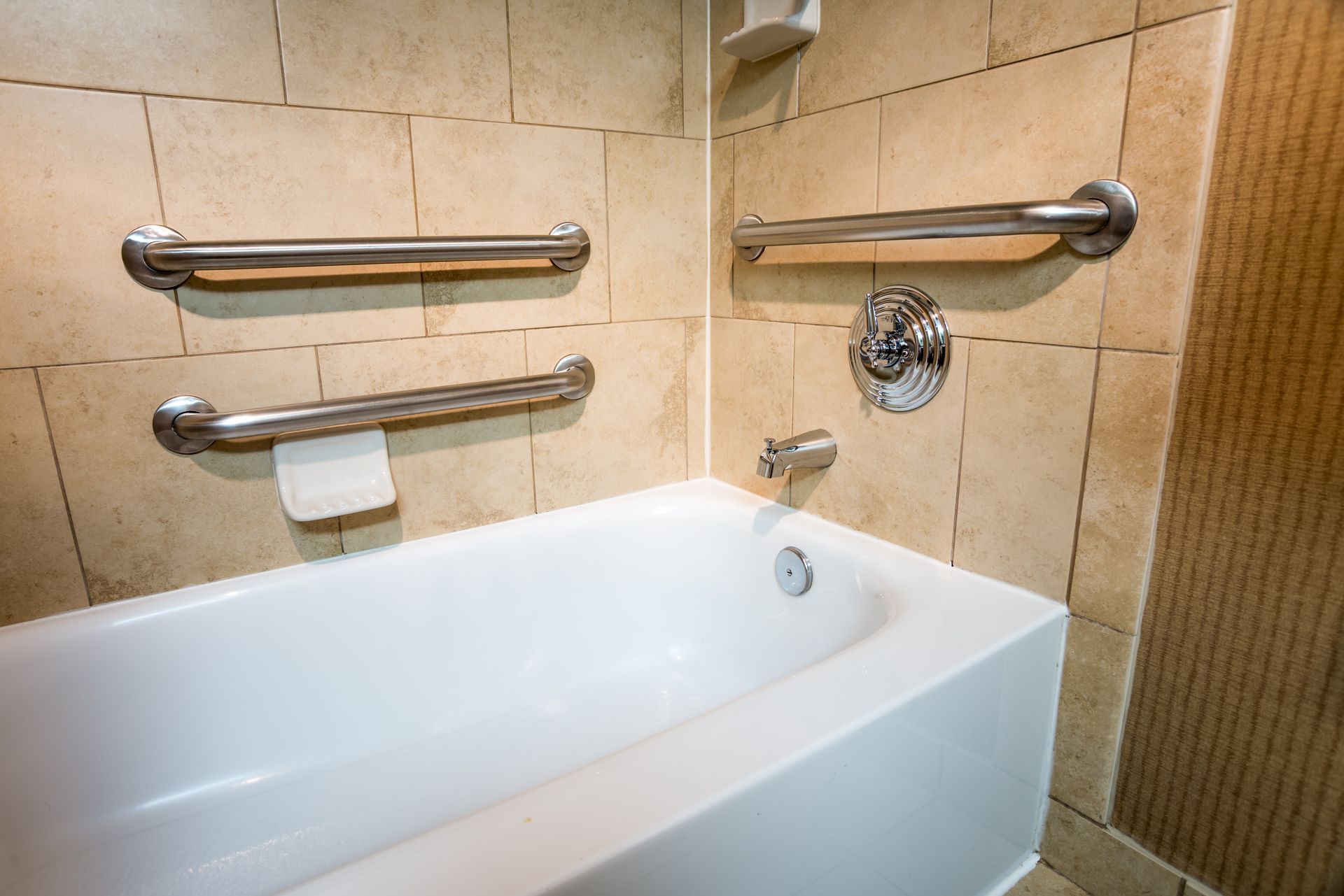 Modern bathroom featuring a concrete vessel sink, wall-mounted faucet, herringbone tile shower, and white tiled floor.