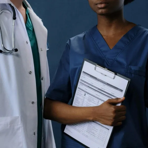 Doctor and nurse in scrubs holding a clipboard in a medical setting