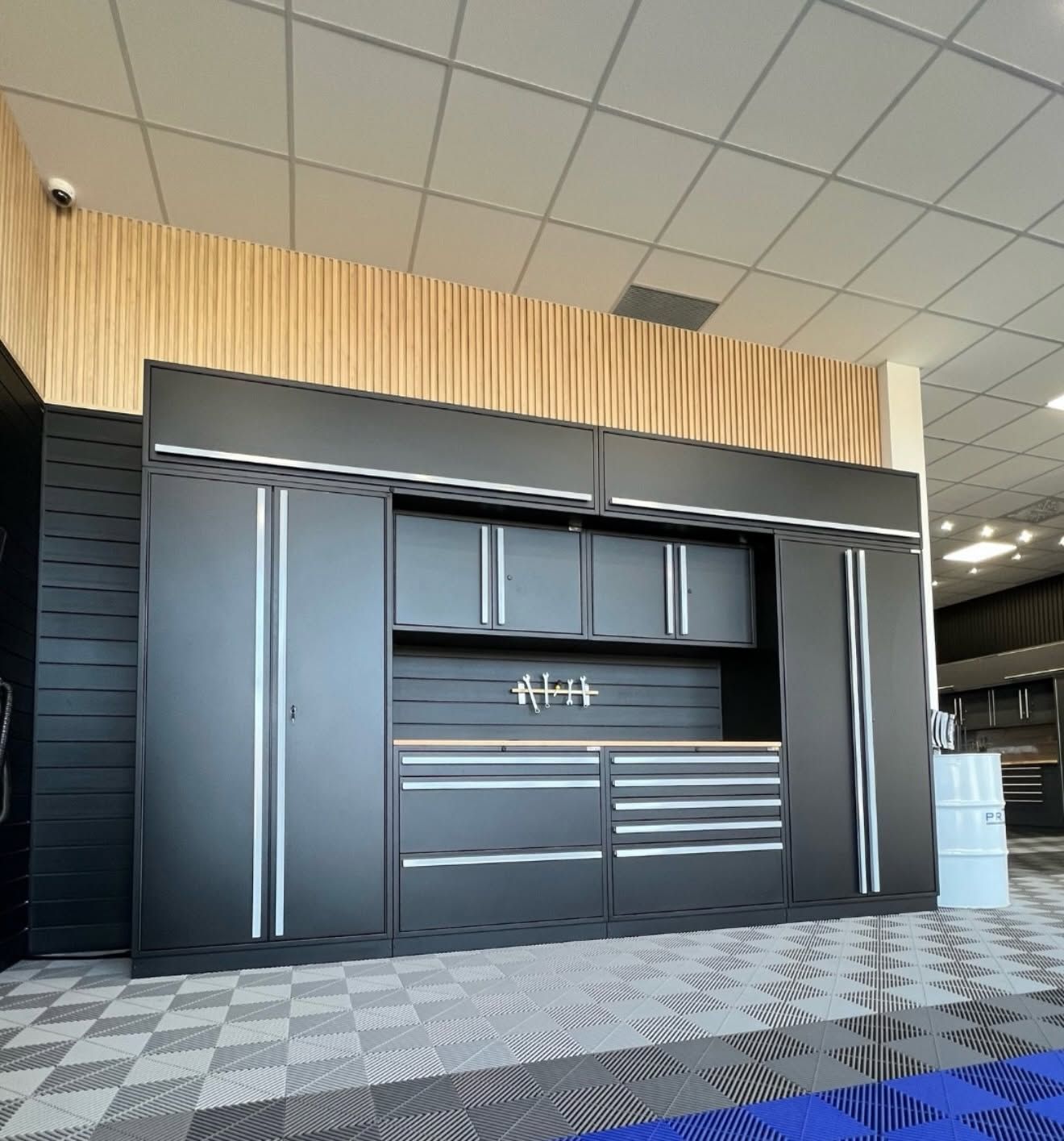 Modern garage with dark gray cabinets and wood slat wall in a showroom
