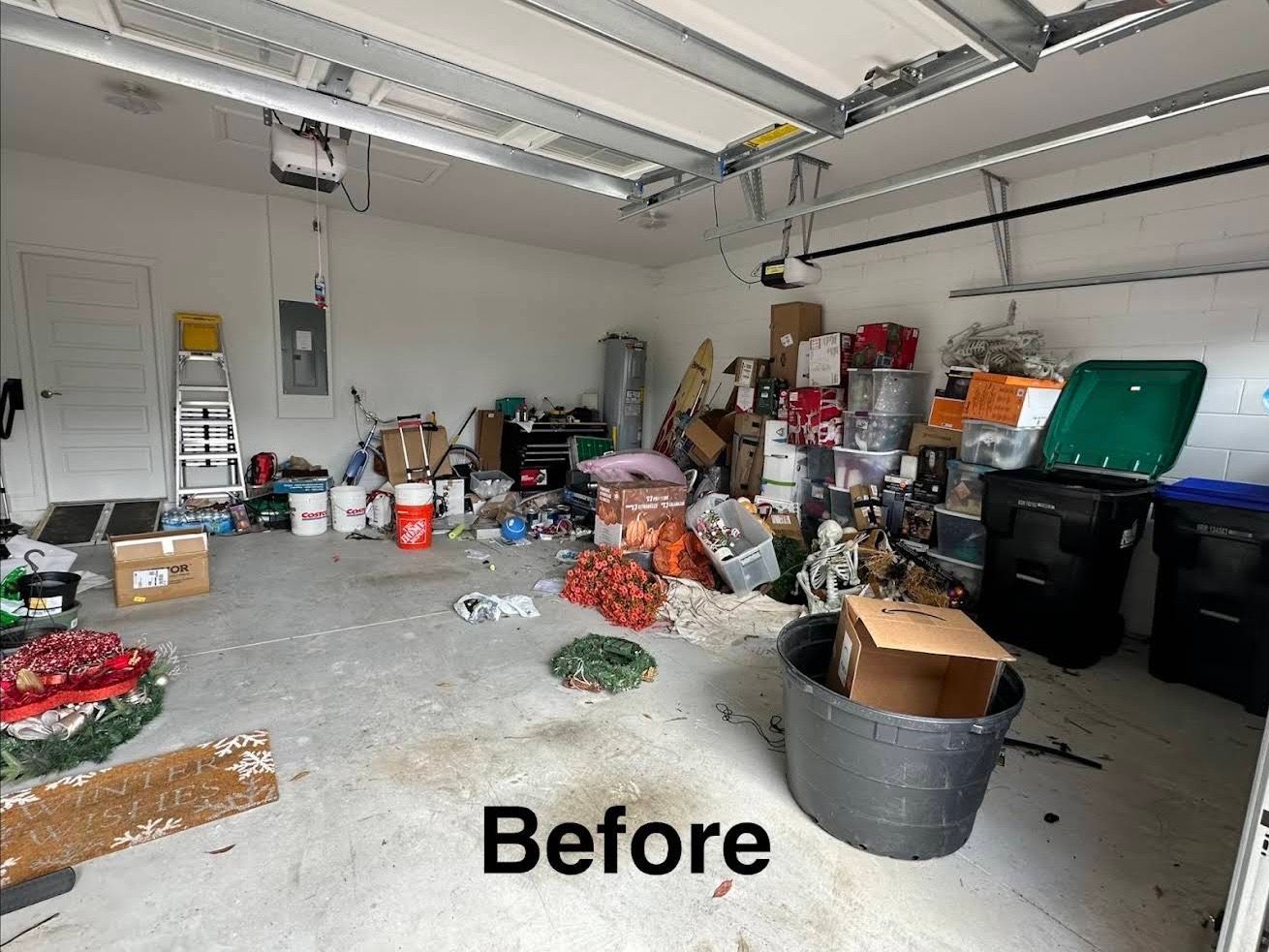 Cluttered garage with boxes, bins, tools, and supplies scattered across the floor and shelves.