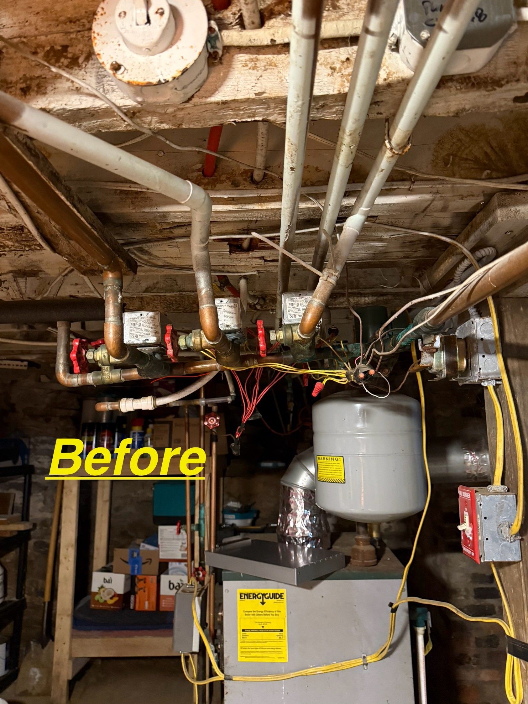 A basement view of residential heating pipes and a water heater tank, labeled 