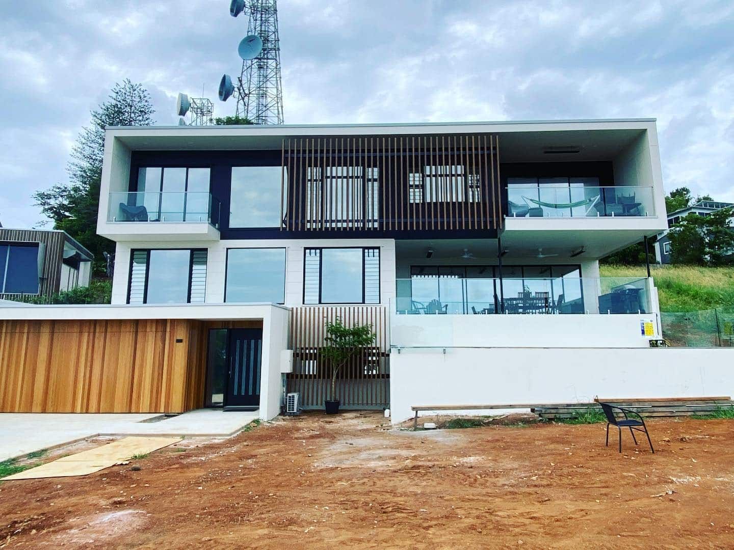 A Large White House With A Lot Of Windows Is Sitting On Top Of A Dirt Hill — Home Tint Sunshine Coast Window Tinting In Maroochydore, QLD