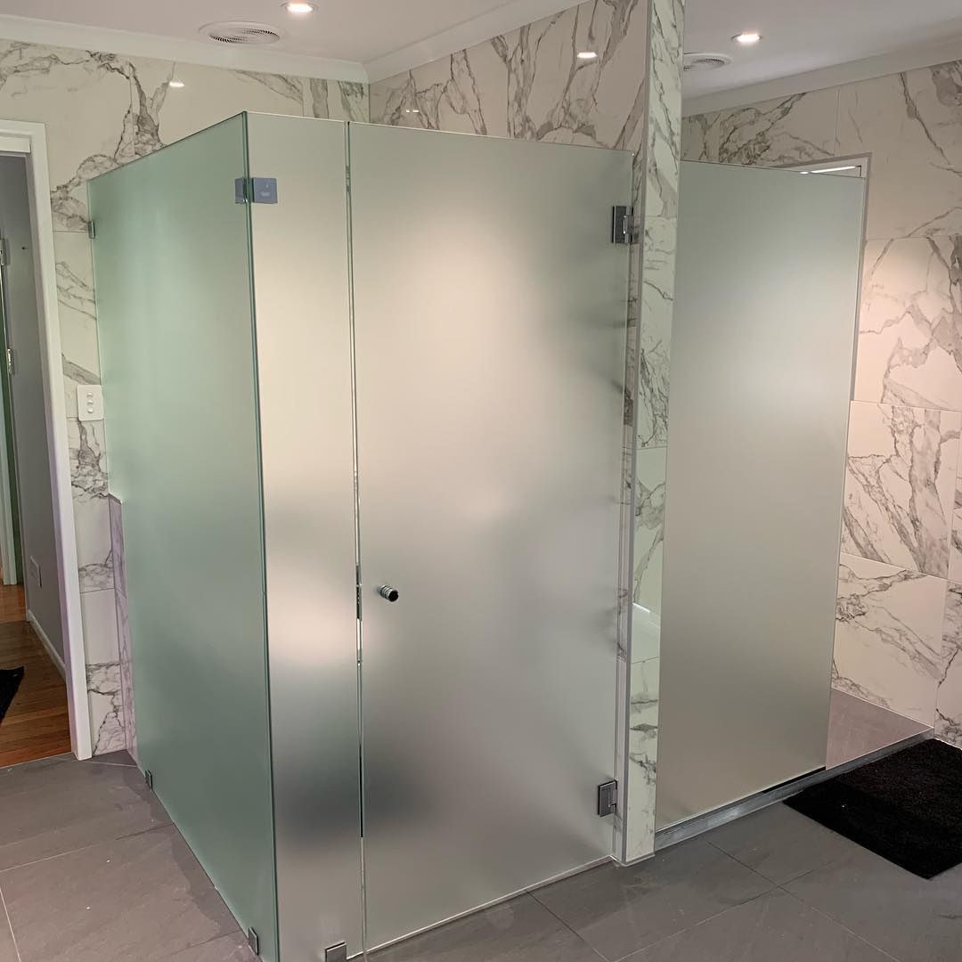 A Bathroom With Two Frosted Glass Shower Doors And Marble Walls — Home Tint Sunshine Coast Window Tinting In Maroochydore, QLD