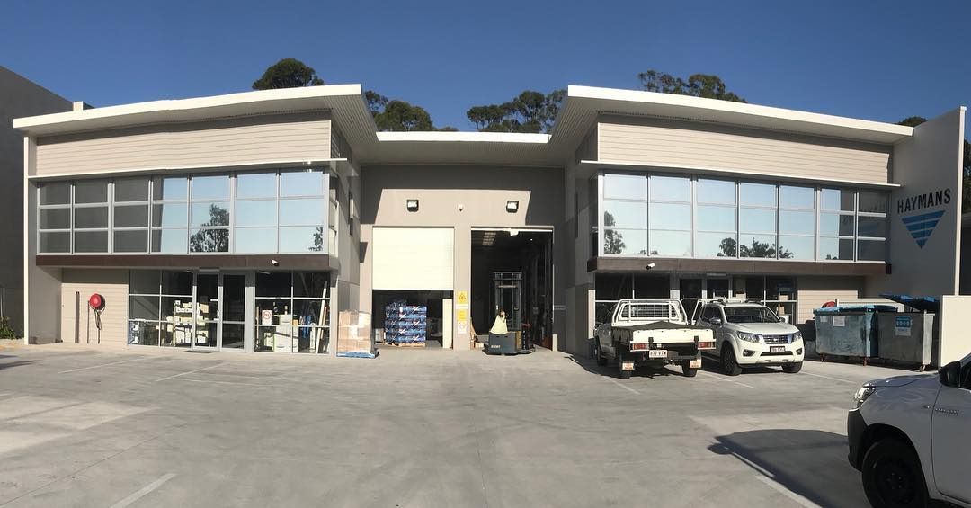 A White Truck Is Parked In Front Of A Large Building — Home Tint Sunshine Coast Window Tinting In Maroochydore, QLD