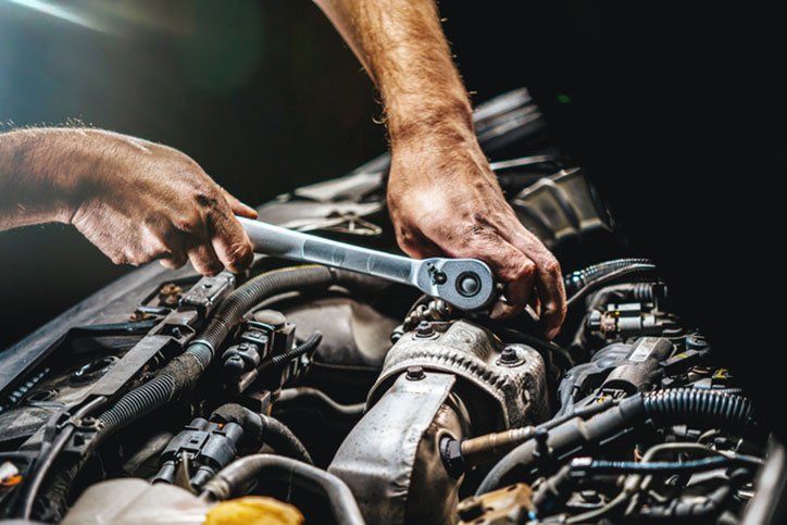 Auto mechanic working on car engine in mechanics garage. Repair service. authentic close-up shot