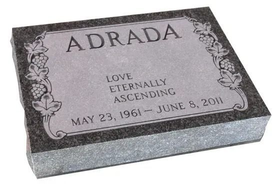 Gray granite gravestone with floral border engraved “ADRADA,” “LOVE, ETERNALLY ASCENDING,” and dates