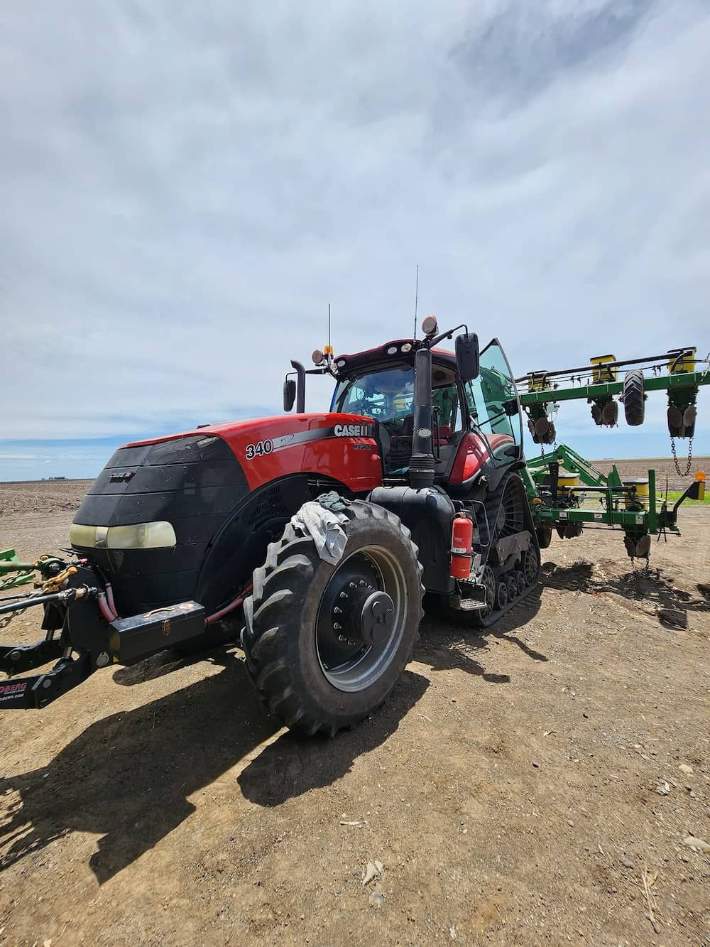 A Red And Black Tractor Is Parked In A Dirt Field — Petrena Windscreens In Millmerran, QLD