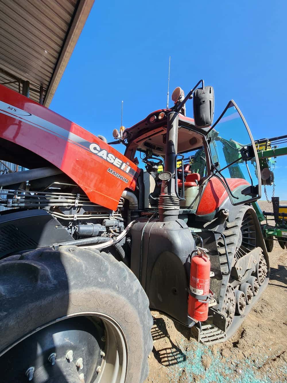 A Red Casen Tractor Is Parked In The Dirt In Front Of A Building — Petrena Windscreens In Aubigny, QLD