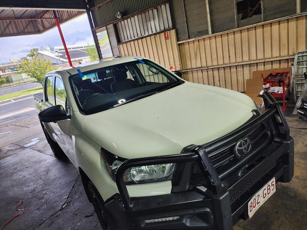 A White Toyota Hilux Truck Is Parked In A Garage — Petrena Windscreens In Cambooya, QLD