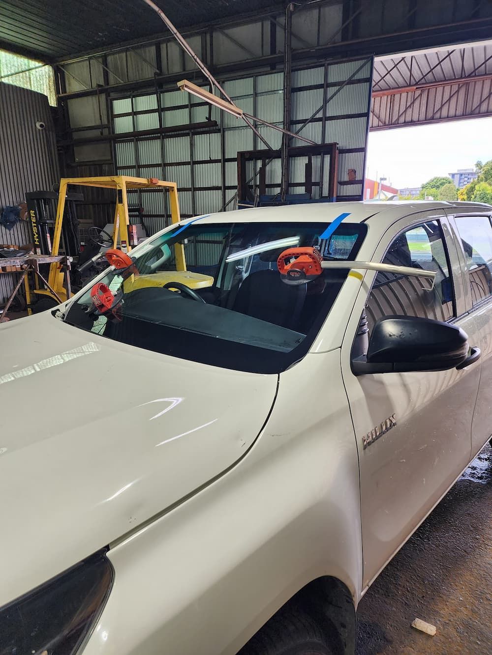 A White Car With A Broken Windshield Is Parked In A Garage — Petrena Windscreens In Leyburn, QLD