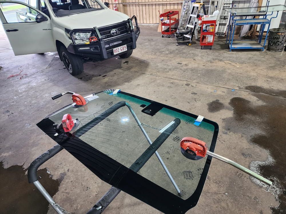A Car Windshield Is Being Replaced In A Garage — Petrena Windscreens In Toowoomba City, QLD