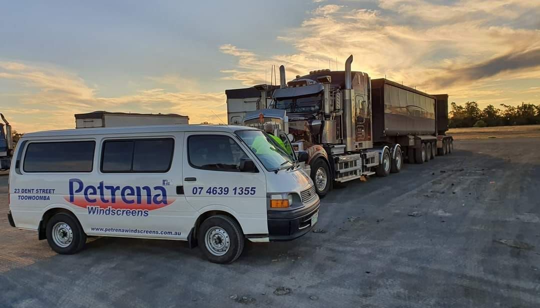 A White Van Is Parked Next To A Large Semi Truck — Petrena Windscreens In Toowoomba City, QLD