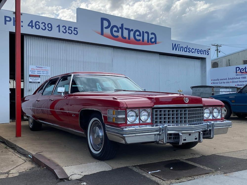A Red Car Is Parked In Front Of A Building That Says Petrena Windscreens — Petrena Windscreens In Toowoomba City, QLD