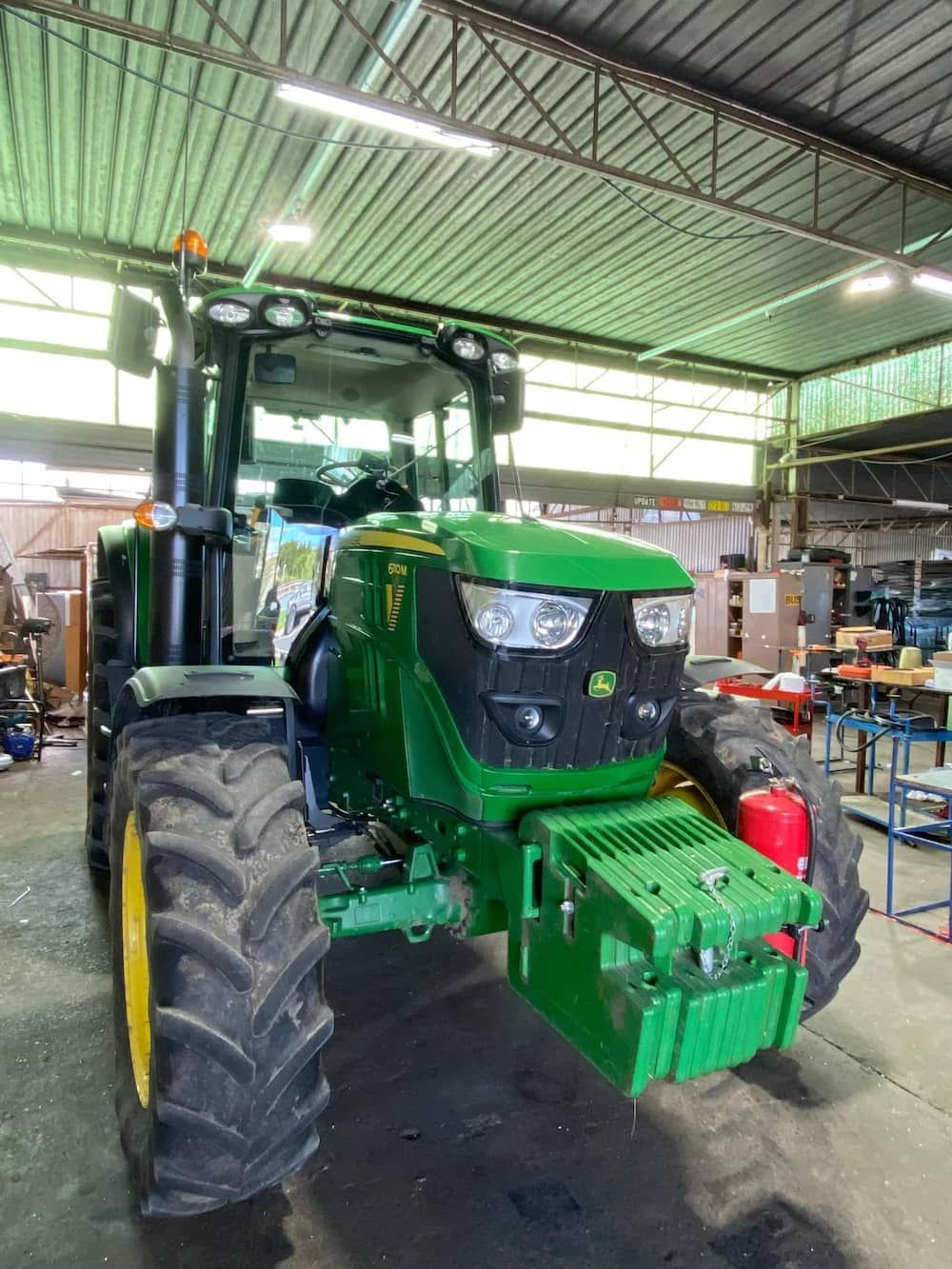 A Green John Deere Tractor Is Parked In A Garage — Petrena Windscreens In Toowoomba City, QLD
