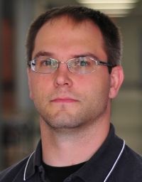 Man with glasses; wearing a black shirt.
