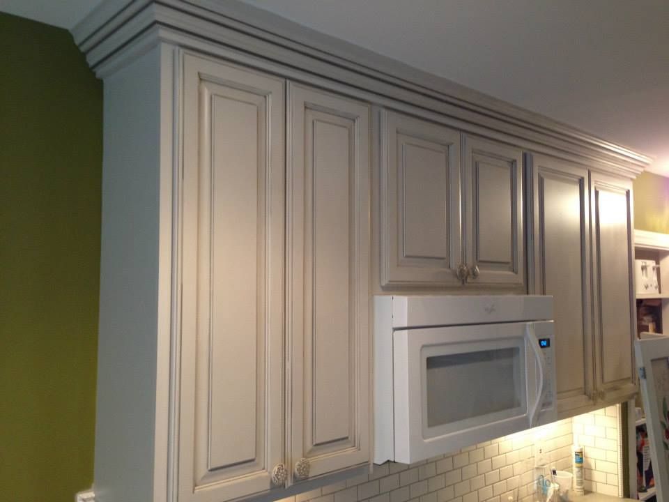A kitchen with white cabinets and a microwave.