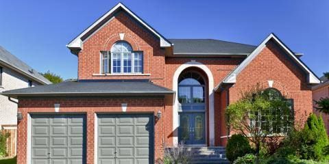 A large red brick house with two garage doors