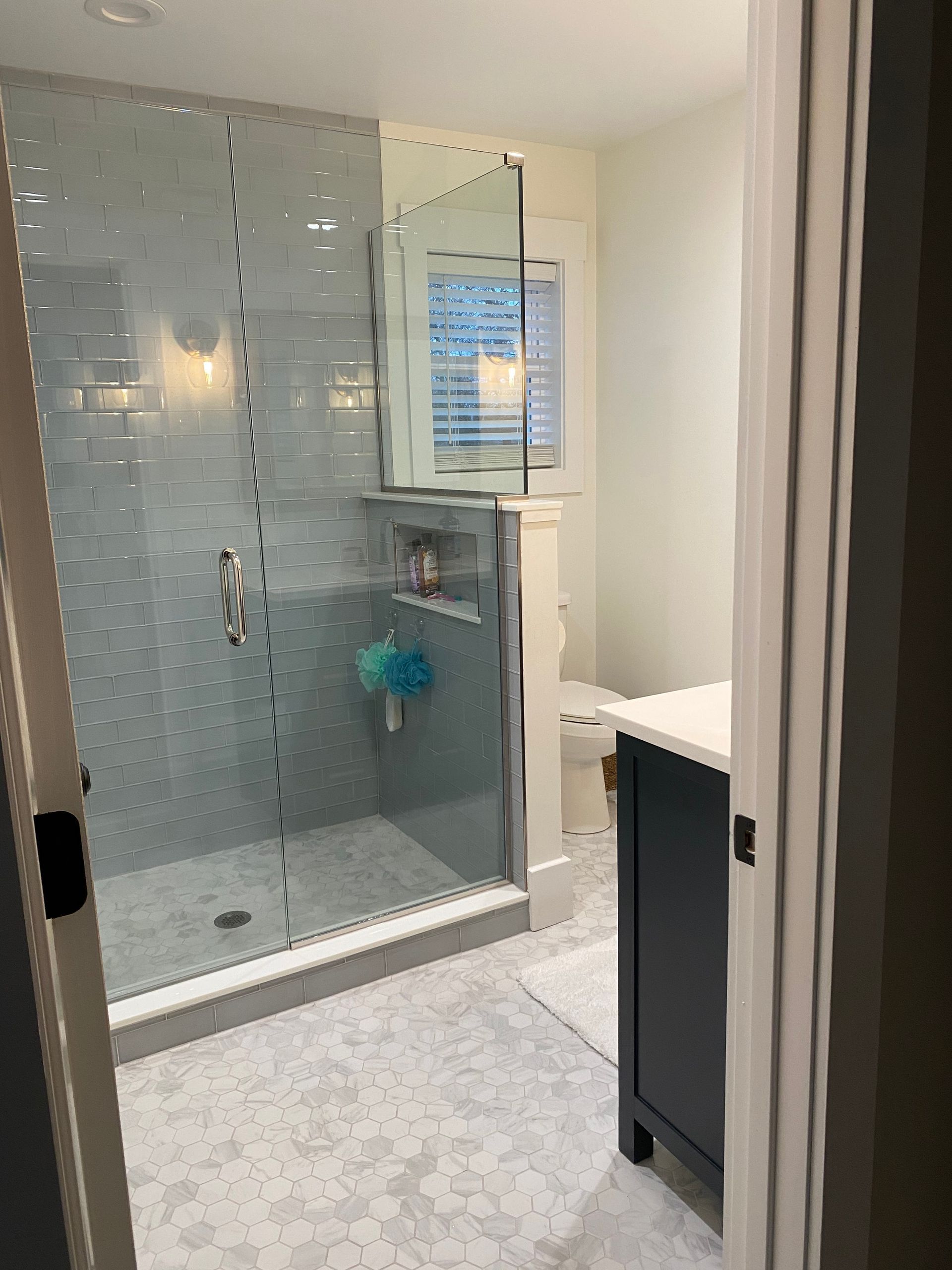 A bathroom with a walk in shower and a toilet.