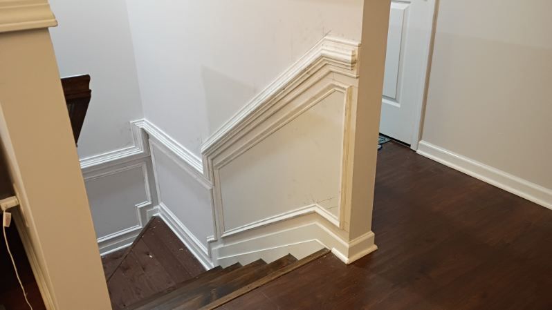 White paneled staircase with dark wooden steps.