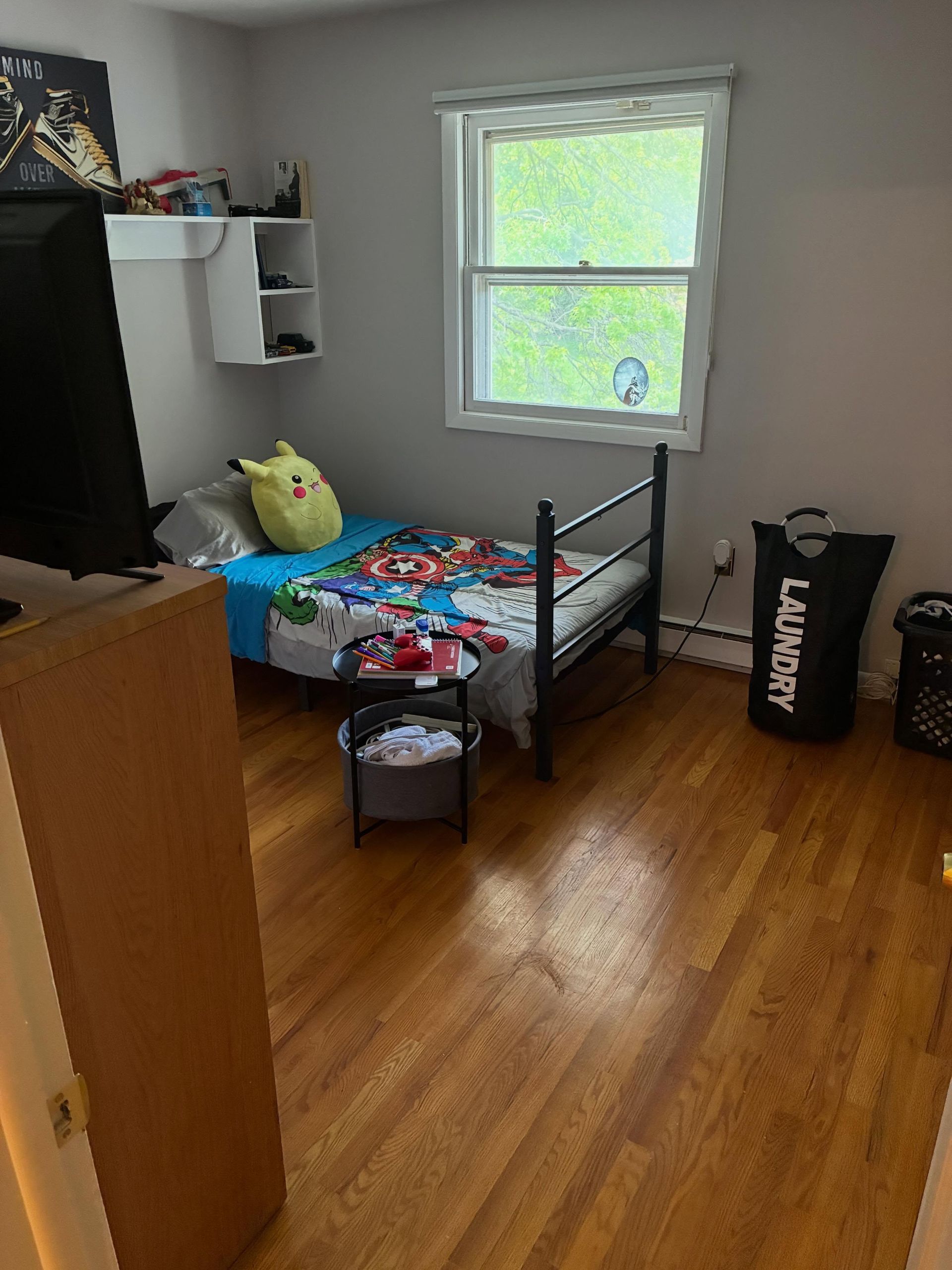 Small bedroom with a single bed, window, hardwood floor, and dark dresser.