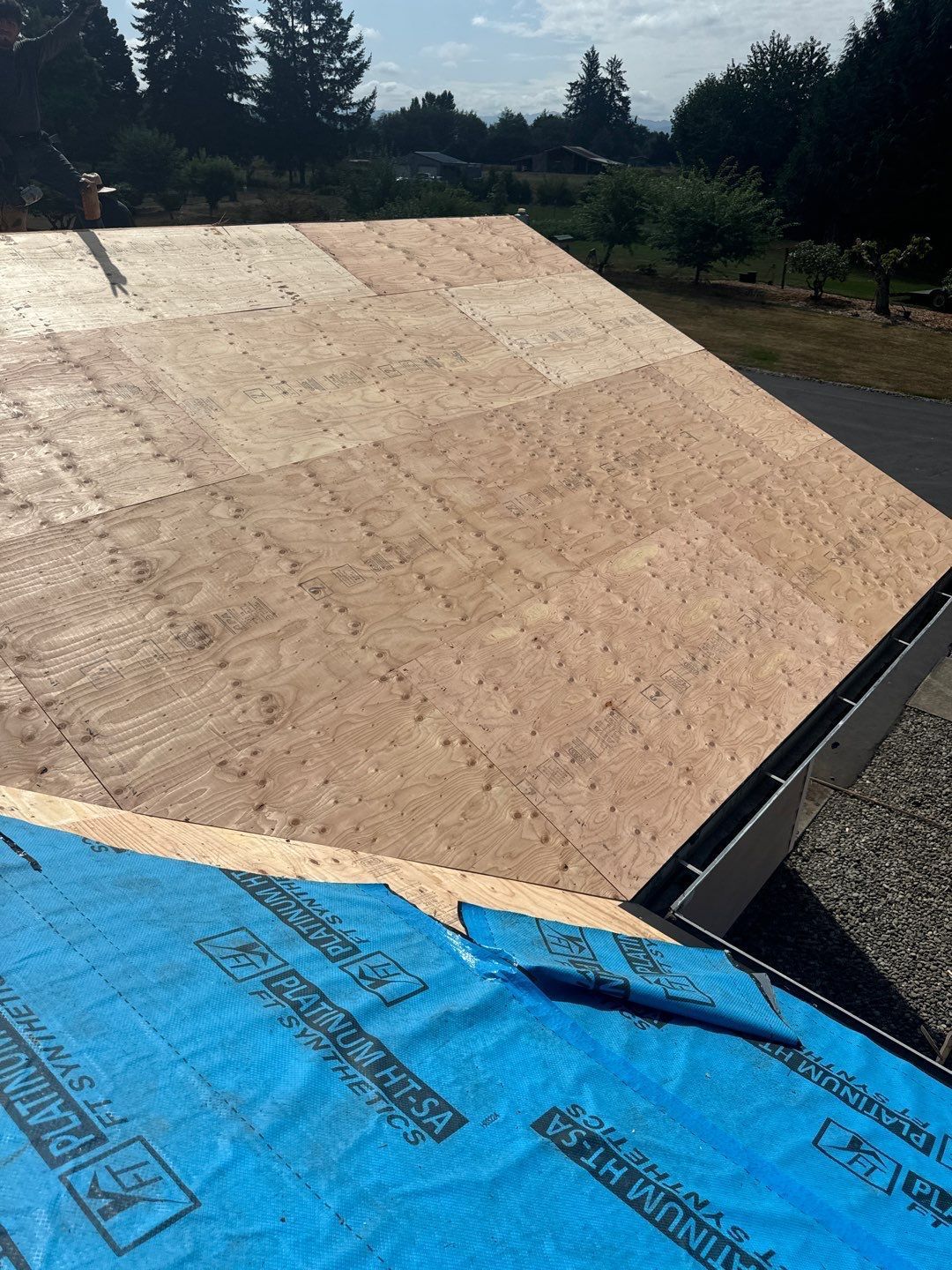 Roofing professionals repairing storm damage on a home in Lacey, Washington.