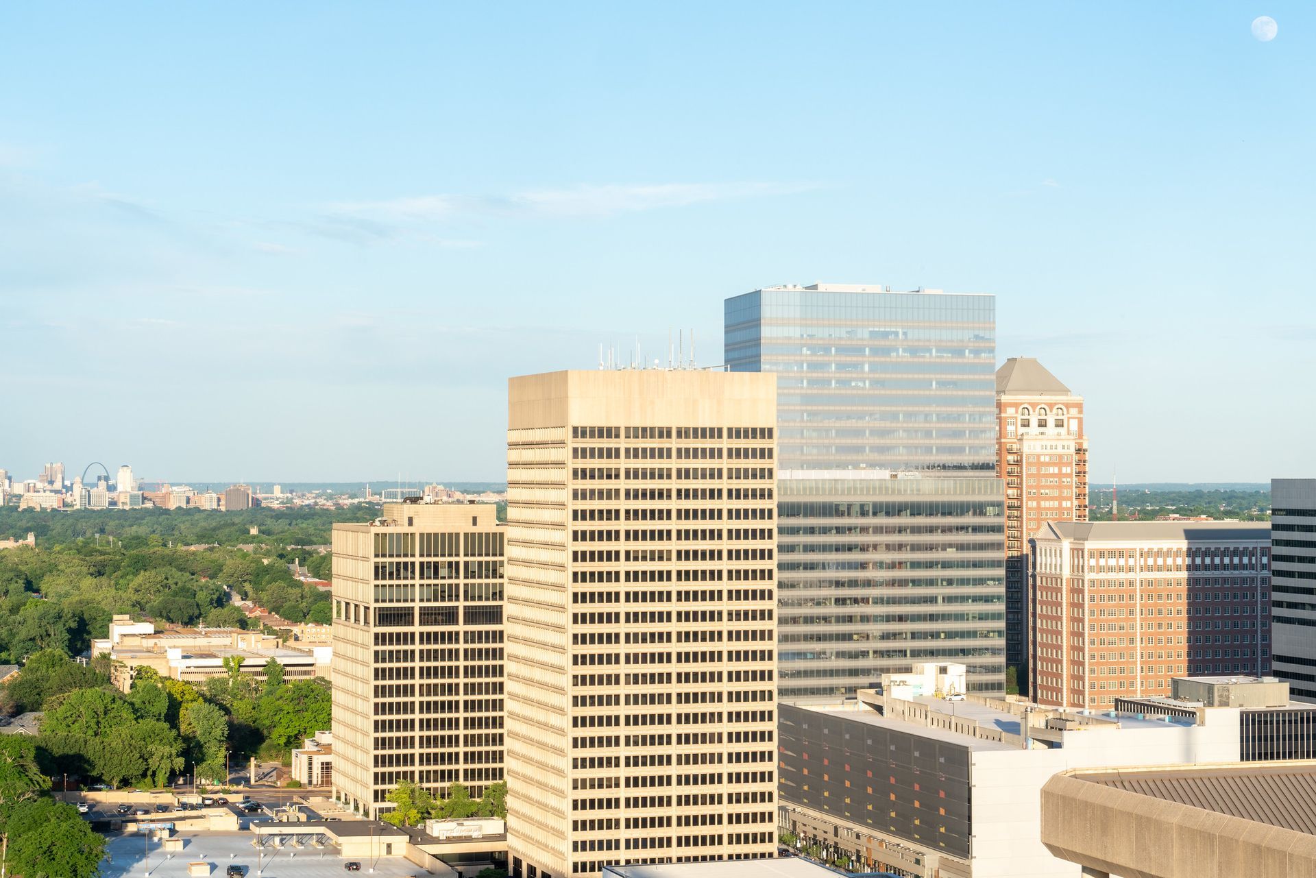 City skyline with several tall buildings under a blue sky, possibly downtown.