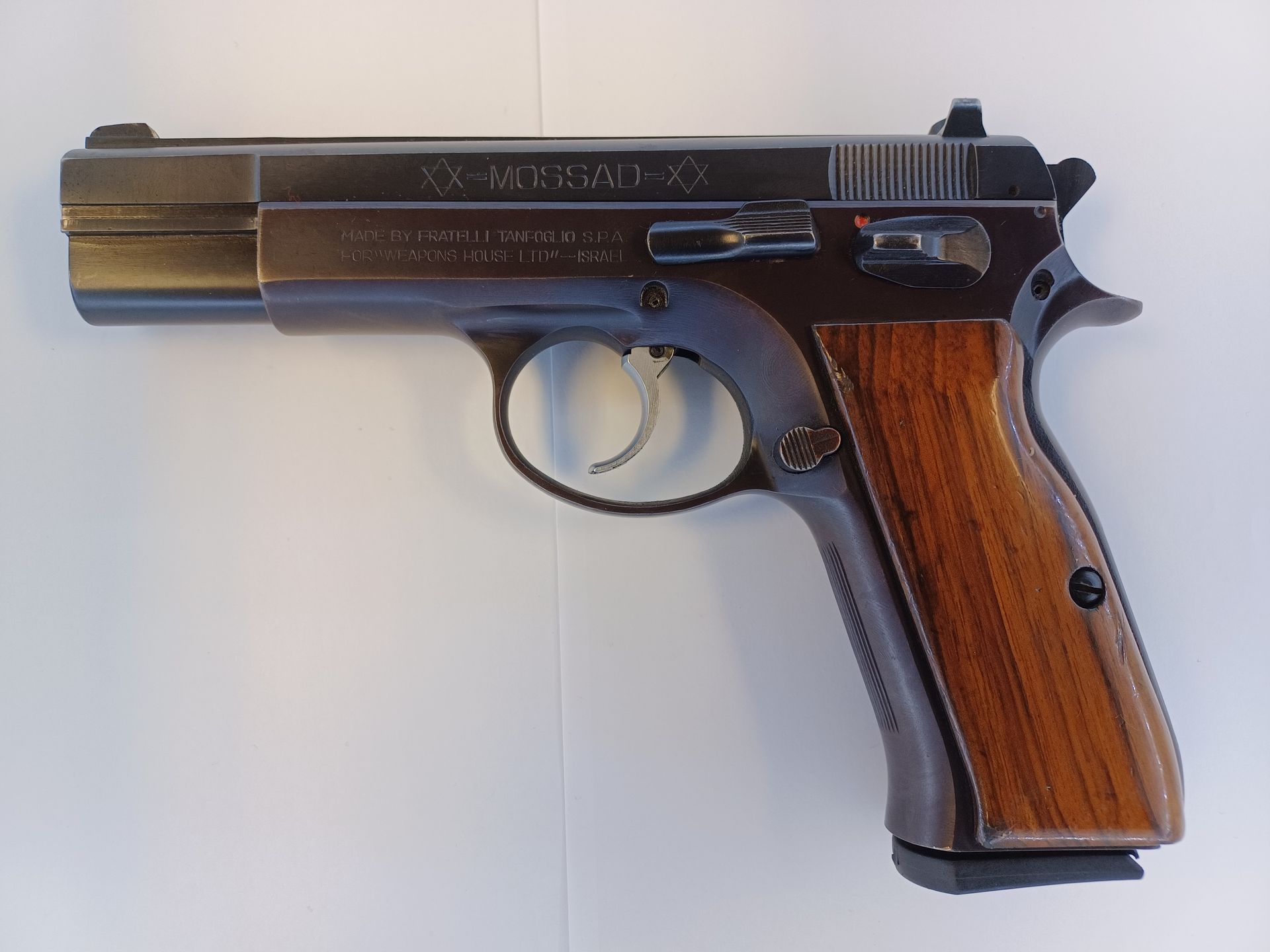 Pistolet CZ 75, acier bleui foncé avec poignées en bois.