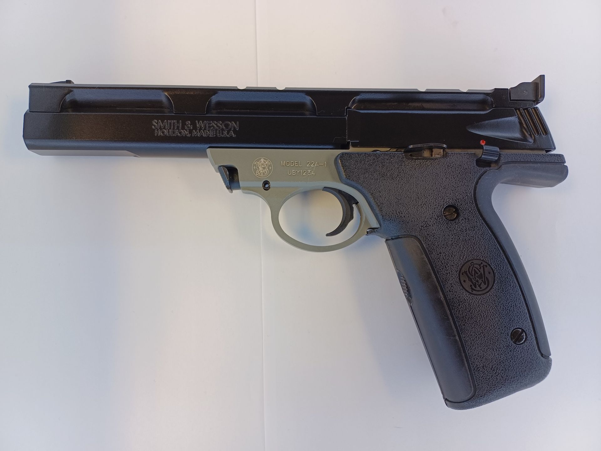 Pistolet Smith & Wesson noir et gris sur une surface blanche.
