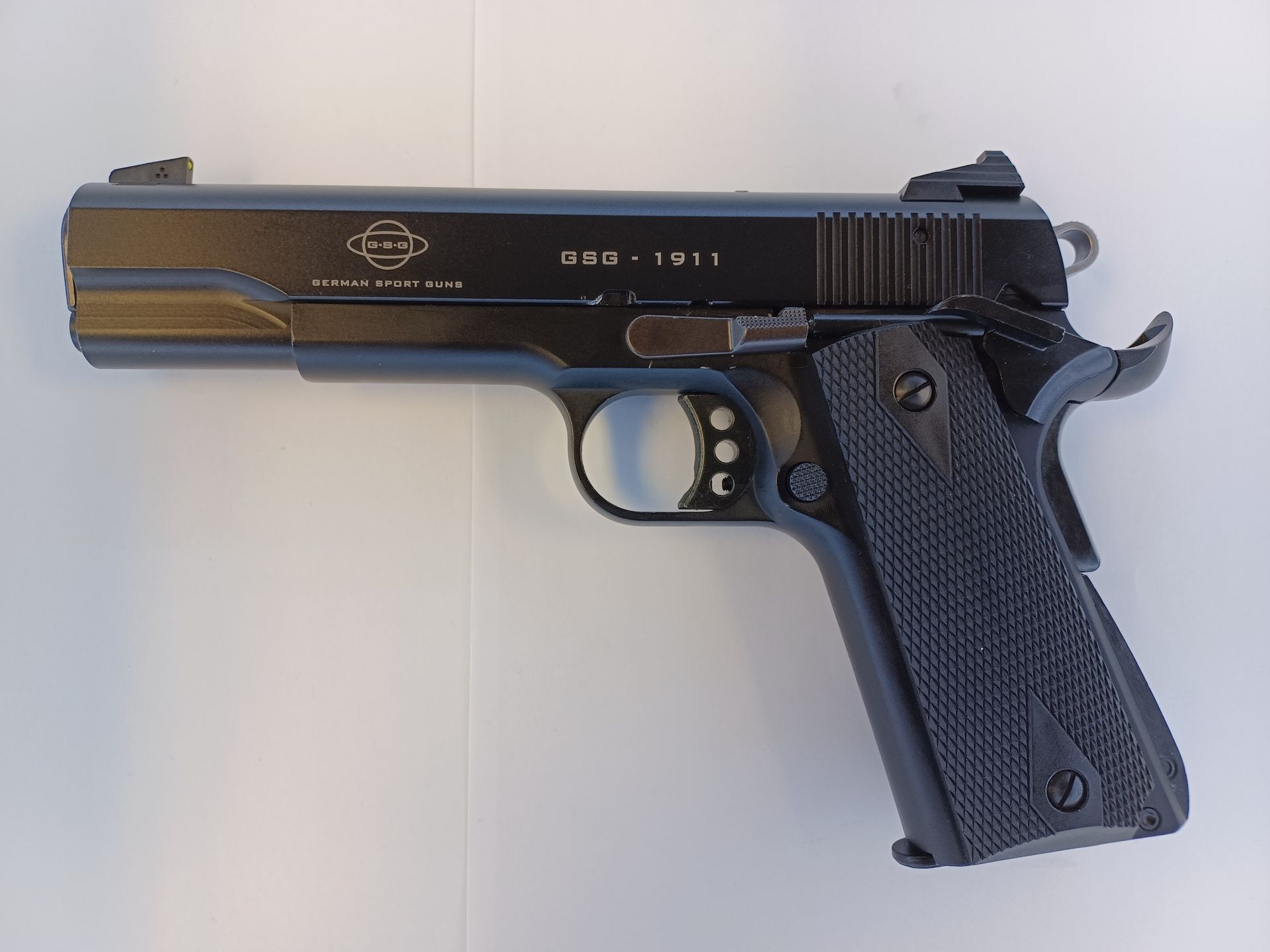Pistolet semi-automatique noir sur une surface blanche.