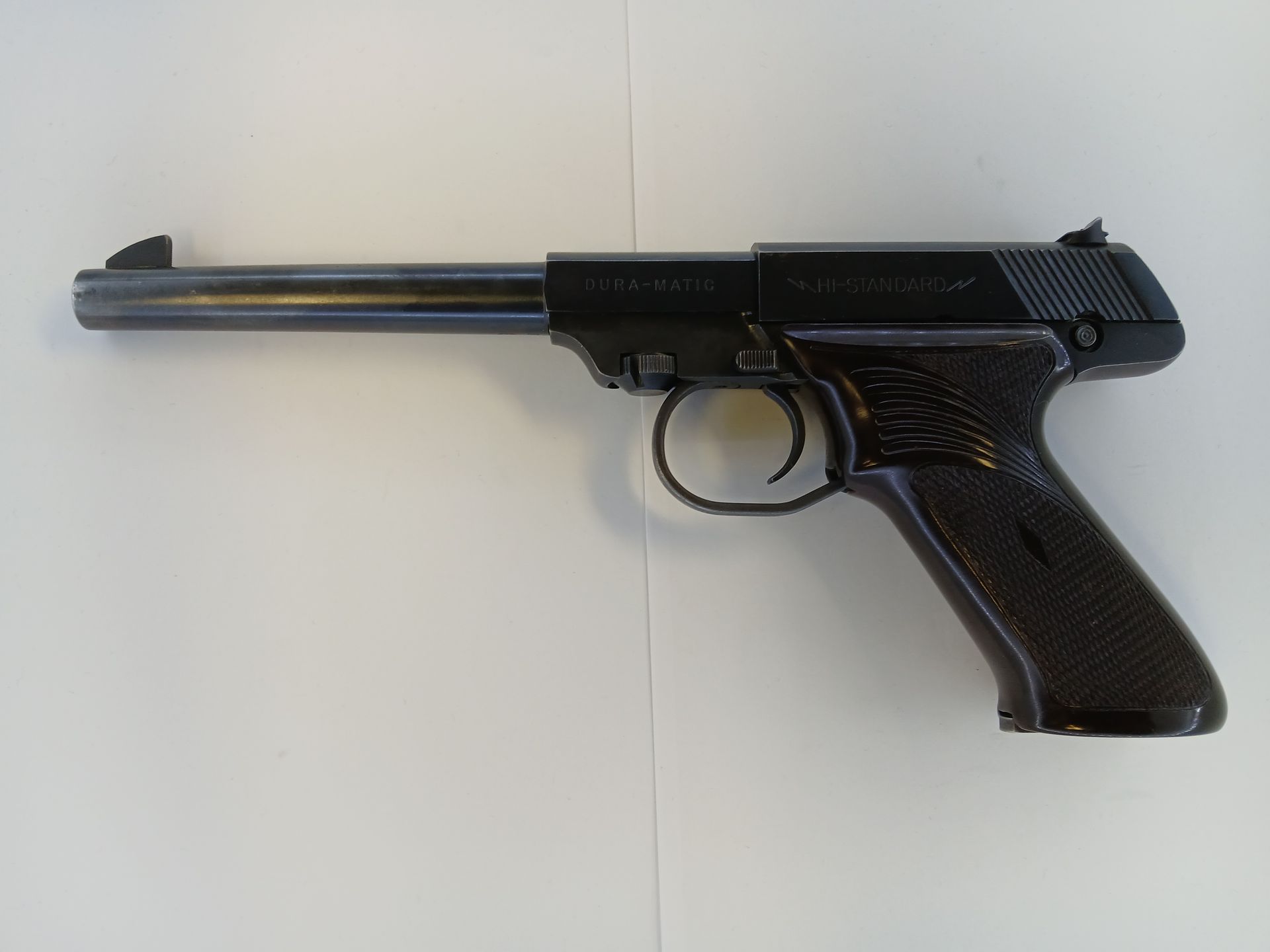 Pistolet à air comprimé noir sur fond blanc.
