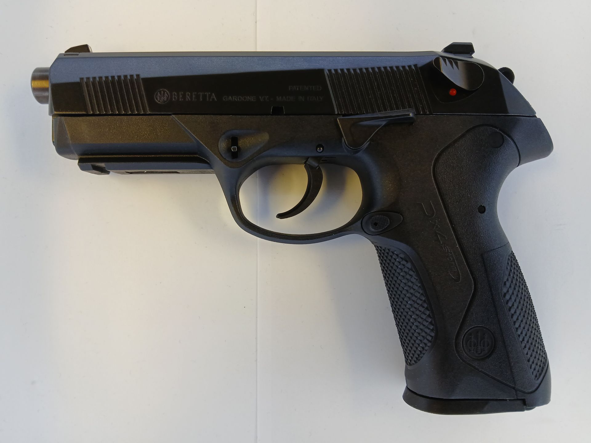 Pistolet Beretta PX4 Storm noir sur une surface blanche, montrant son profil.