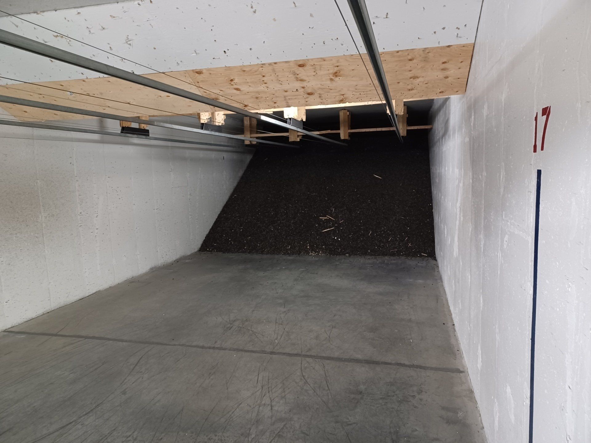 Piste de tir avec murs en béton, un écran de protection en terre et un support de cible.