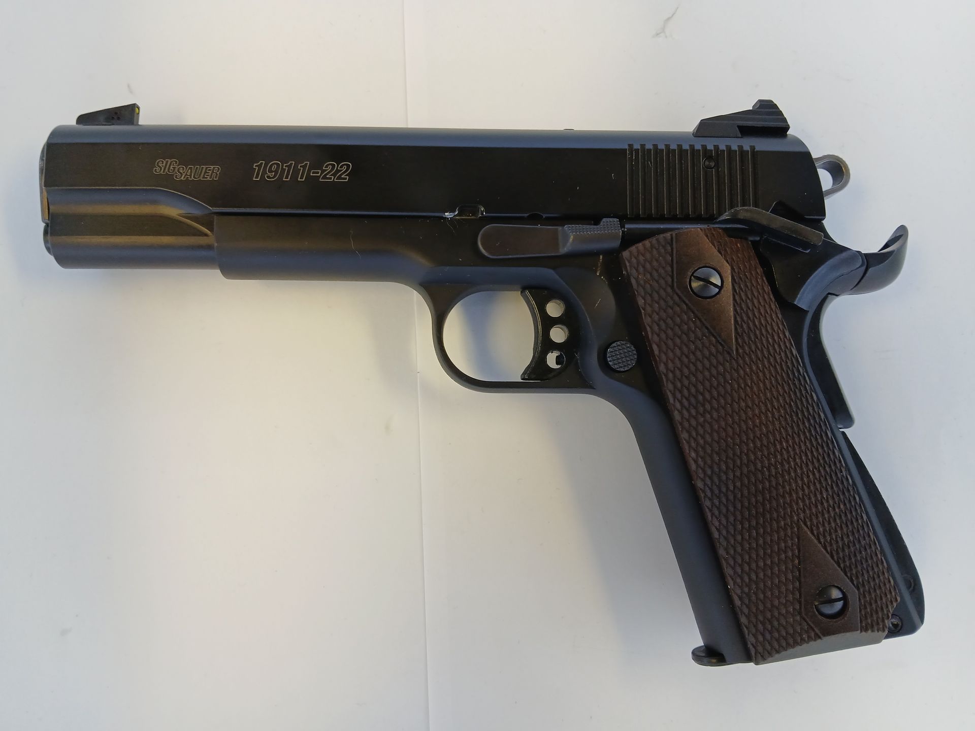 Pistolet noir avec poignées marron.