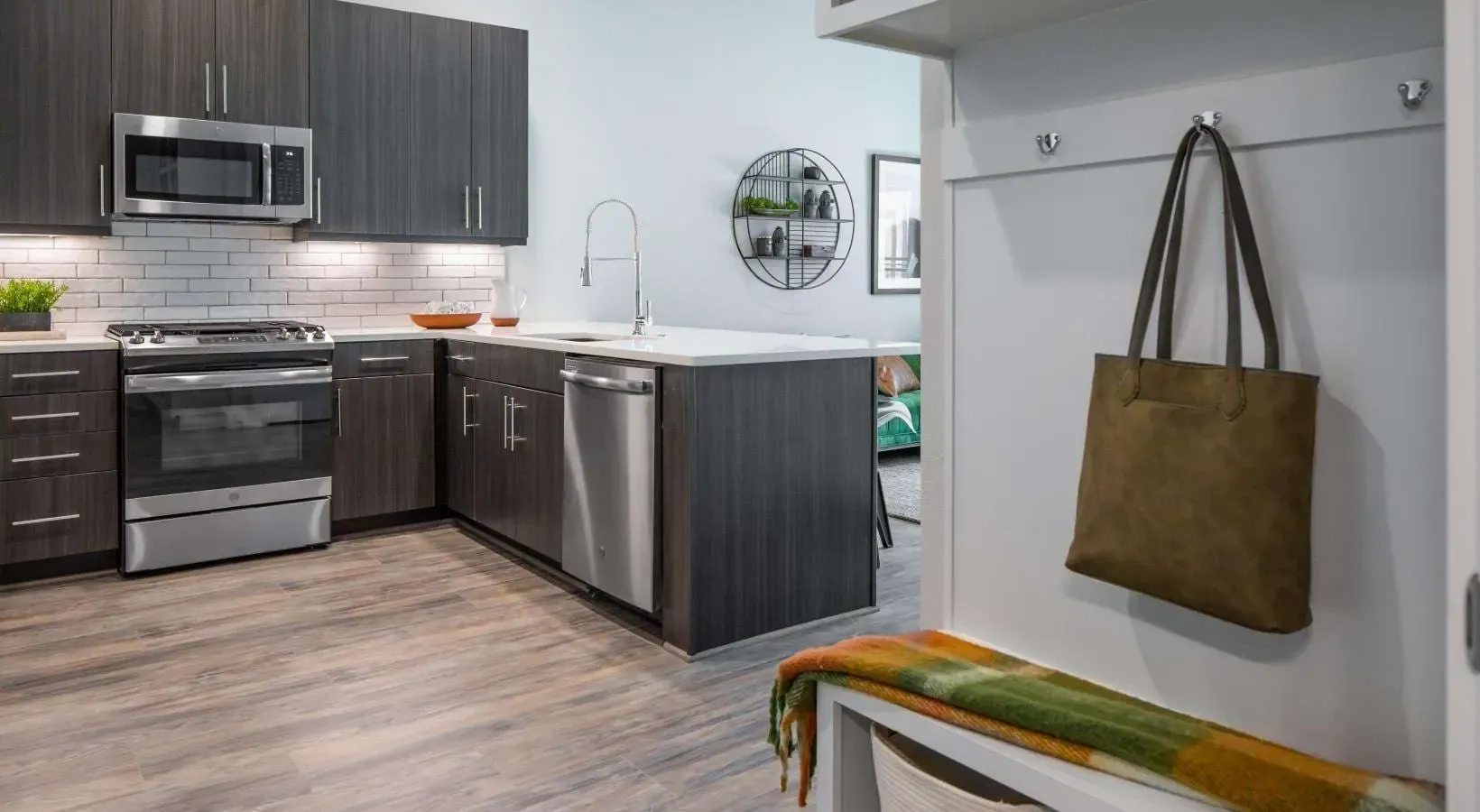 Modern kitchen with dark wood cabinets, stainless steel appliances, and subway tile backsplash.