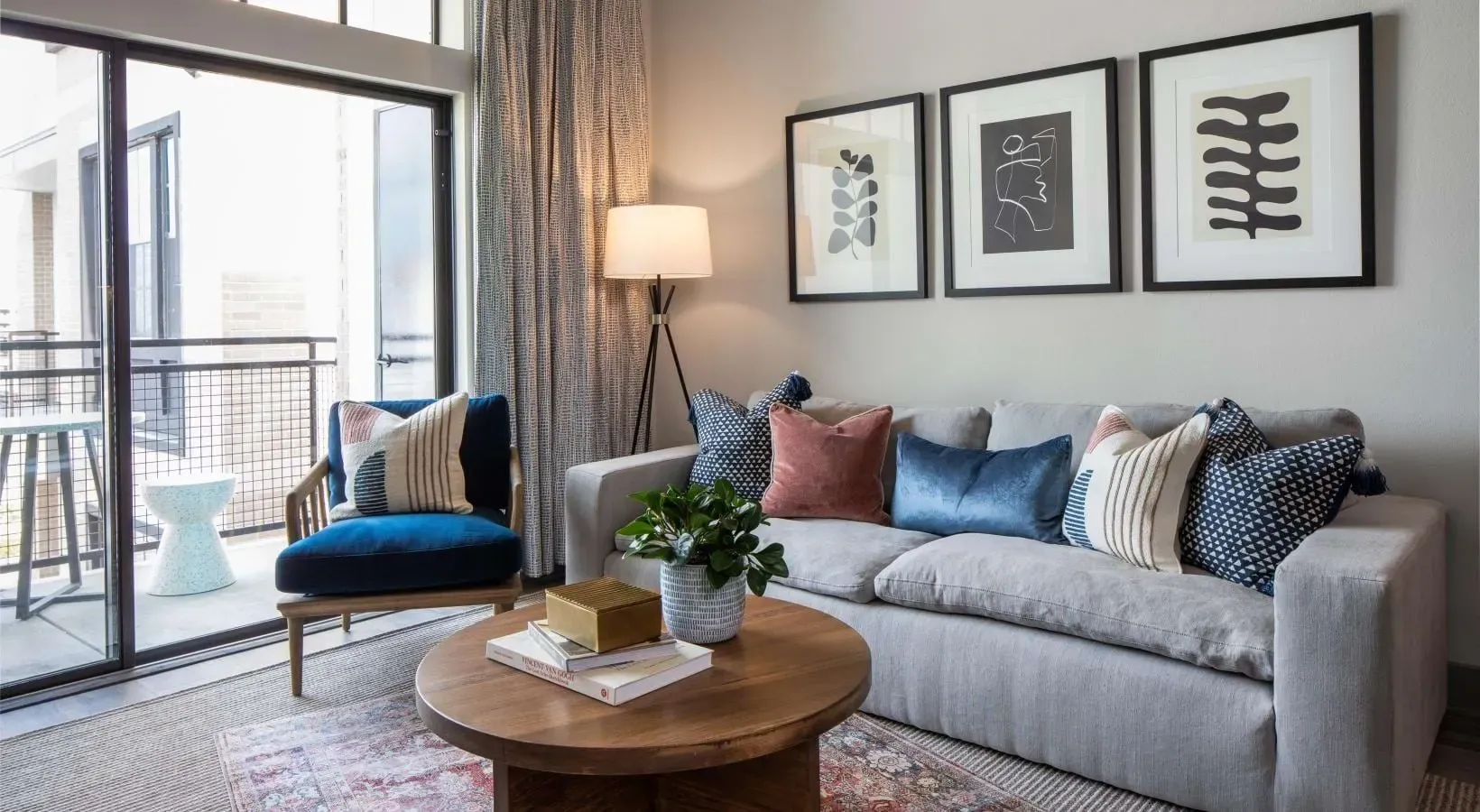 Living room with sofa, accent chair, coffee table, and balcony access.