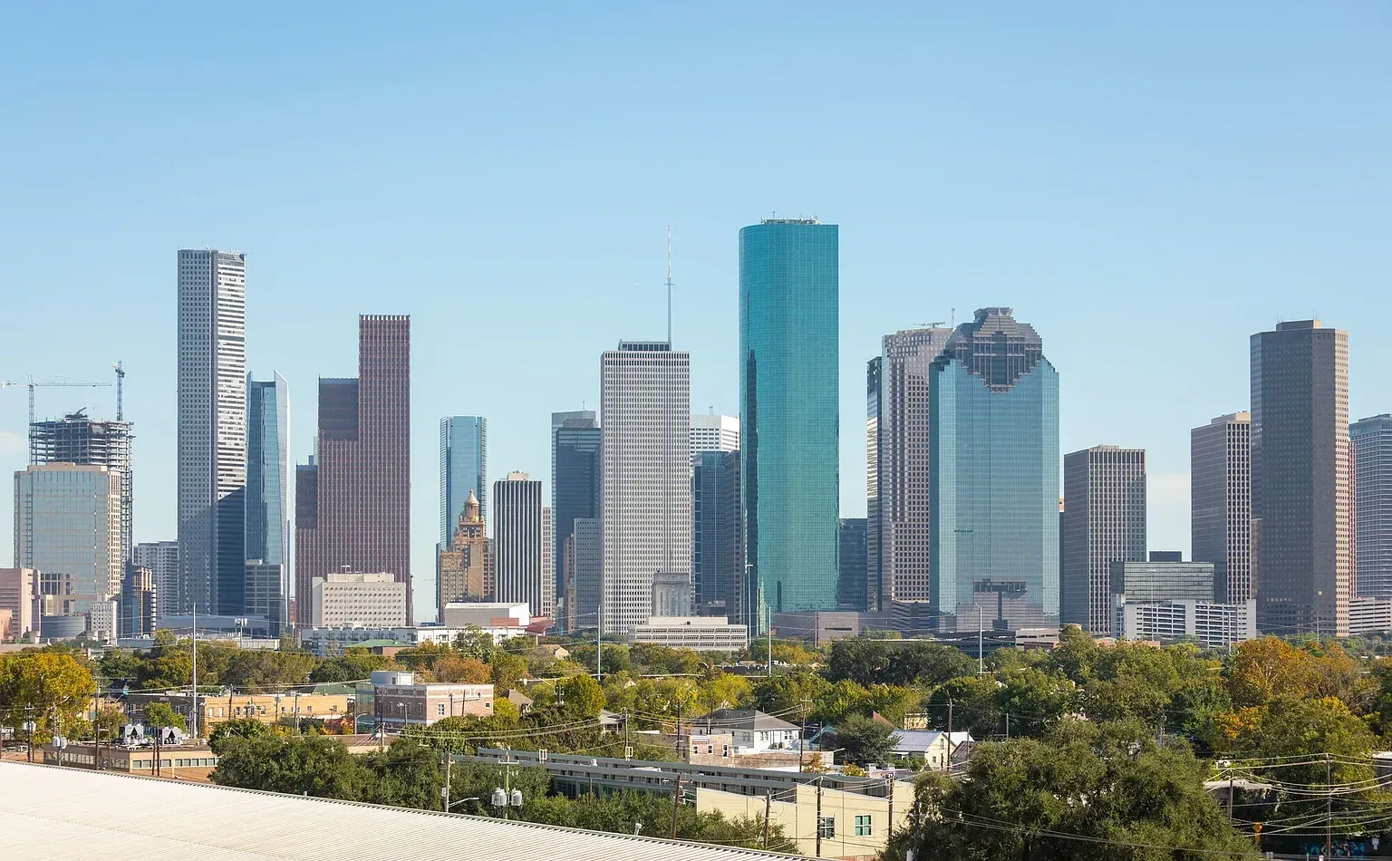 City skyline with modern high-rise buildings under a clear blue sky.
