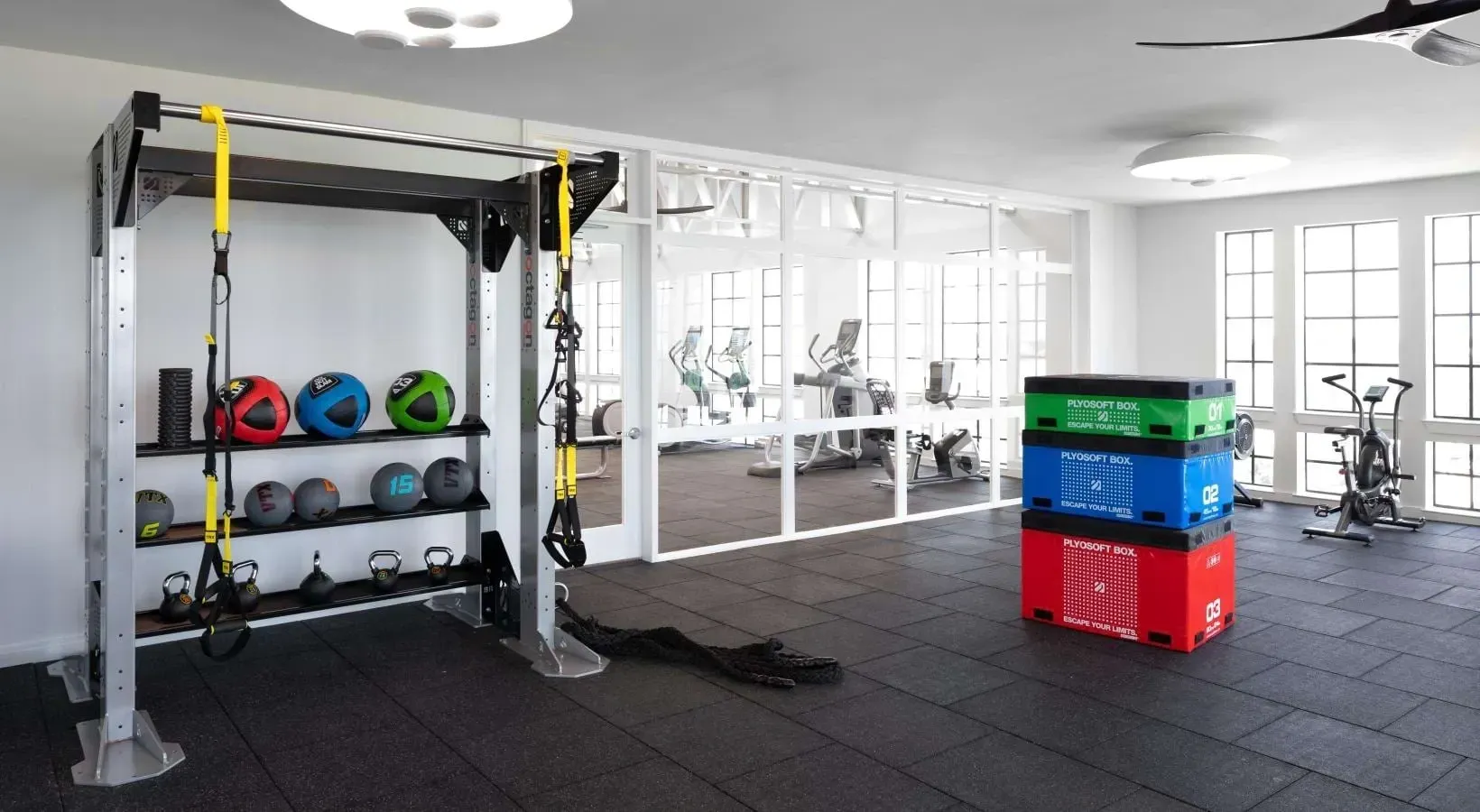 Fitness center with weight training equipment, cardio machines, and plyo boxes.