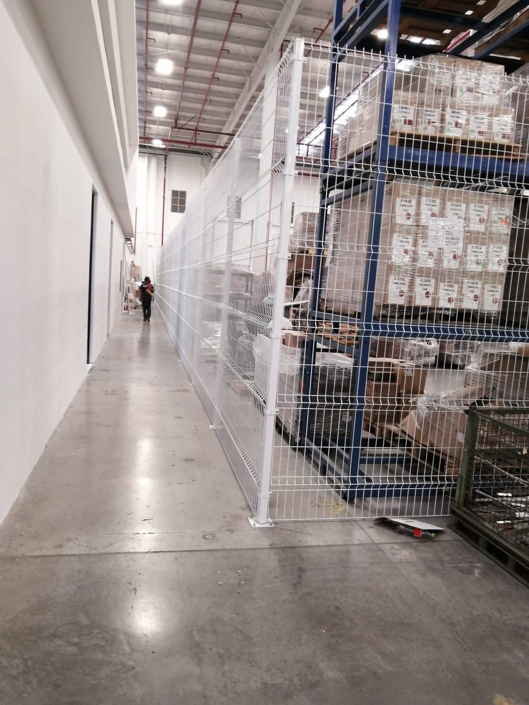 Una persona camina por un pasillo en un almacén.