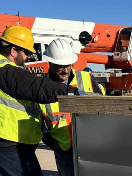 Construction workers in hard hats inspecting a concrete structure at a work site