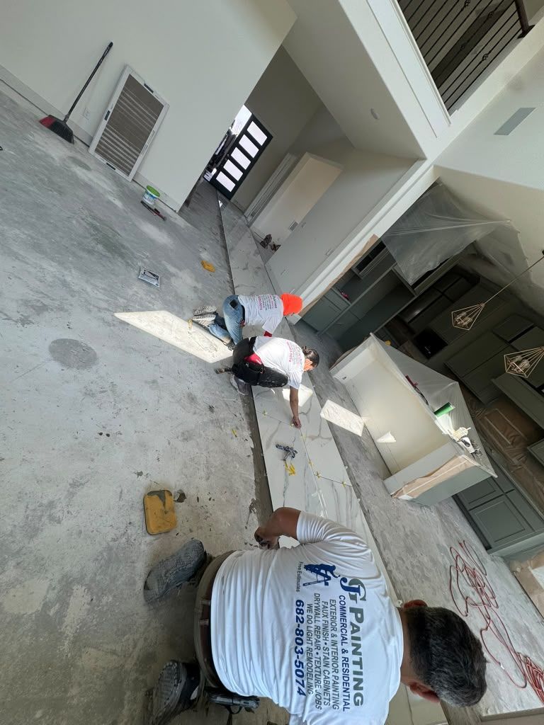 Workers cleaning debris in a corridor beside a building, with buckets, tools, and dust scattered on the floor.
