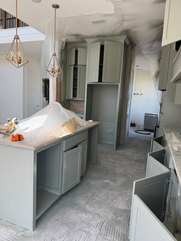 Damaged kitchen with smoke stains, debris on counters, and open cabinets after fire damage