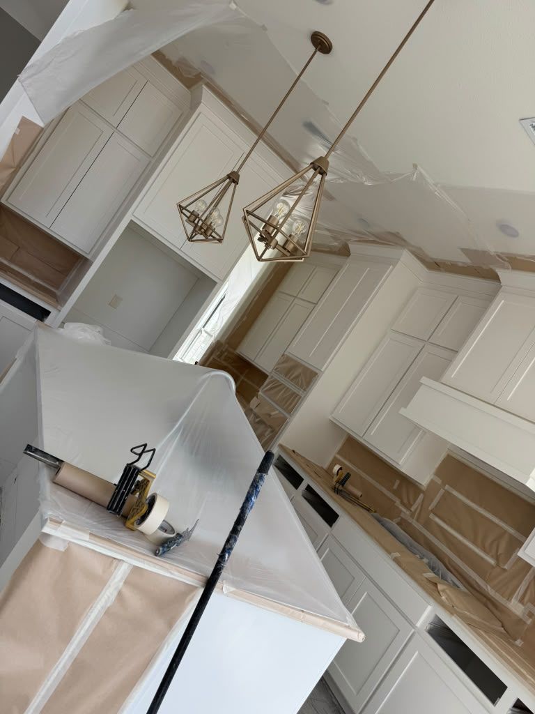 Bright white kitchen with cabinets, island, pendant lights, and a vaulted ceiling.