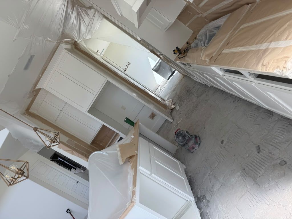 Dusty room with white cabinets, tools, and construction materials during renovation.